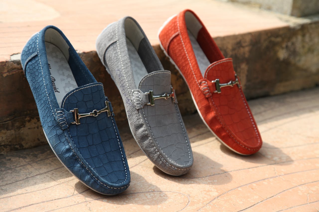 Services-02 Three colorful leather loafers displayed outdoors showcasing style and elegance.