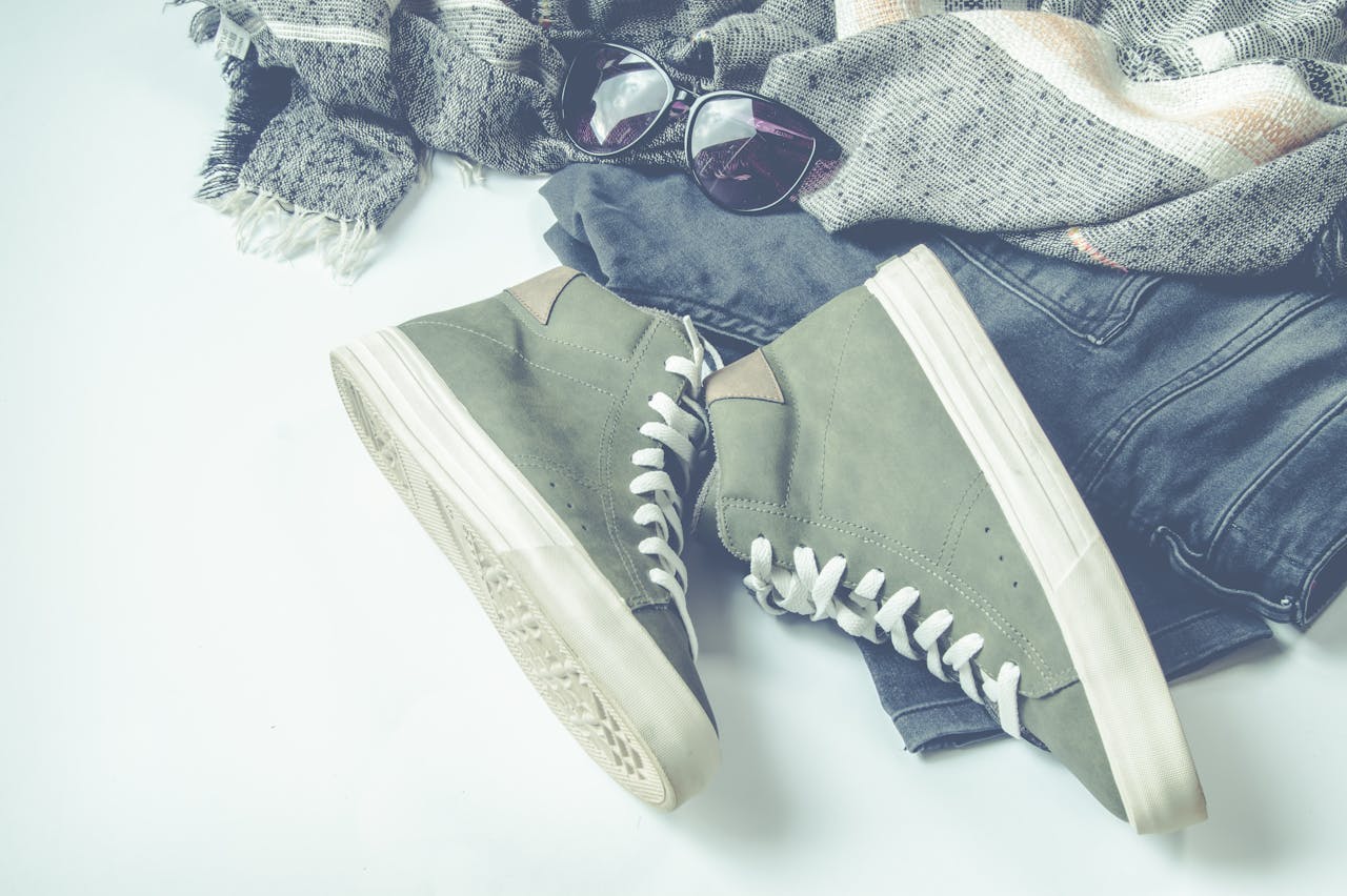 digital-01 Flat lay of casual fashion items including sneakers, sunglasses, and a shawl.